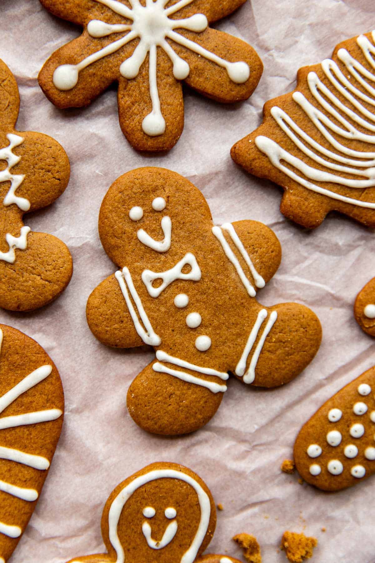 gingerbread man cookies on a piece of white parchment paper decorated with icing. 
