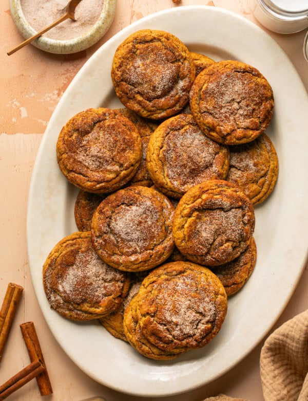 a white oval plate with gingerbread snickerdoodle cookies topped with cinnamon sugar