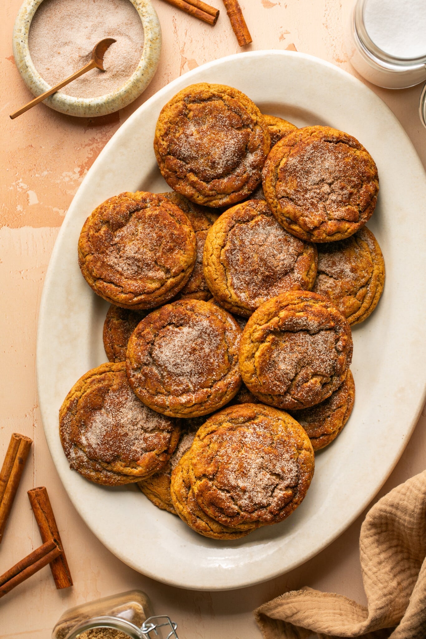 a white oval plate with gingerbread snickerdoodle cookies topped with cinnamon sugar