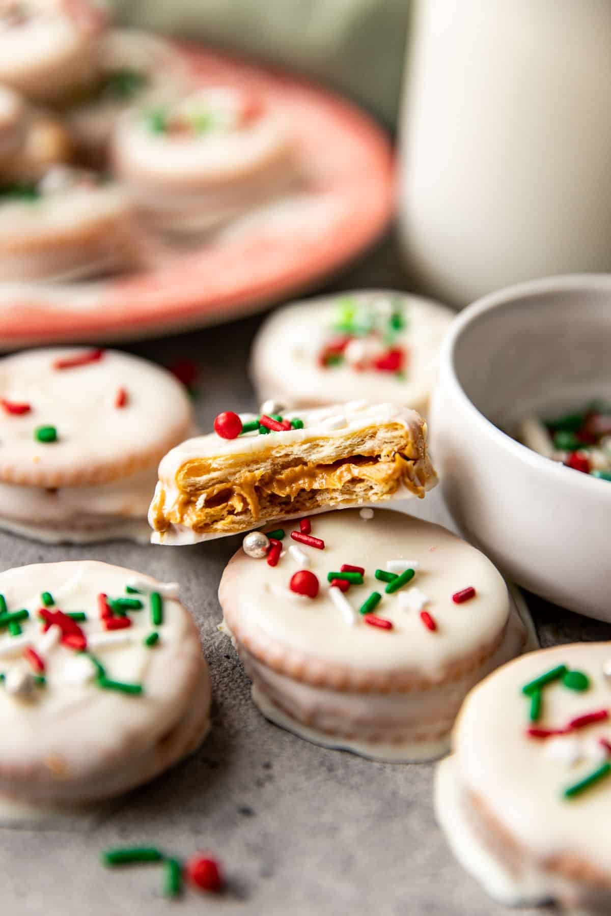 a bite taken out of a ritz cracker cookie decorated with holiday sprinkles. 