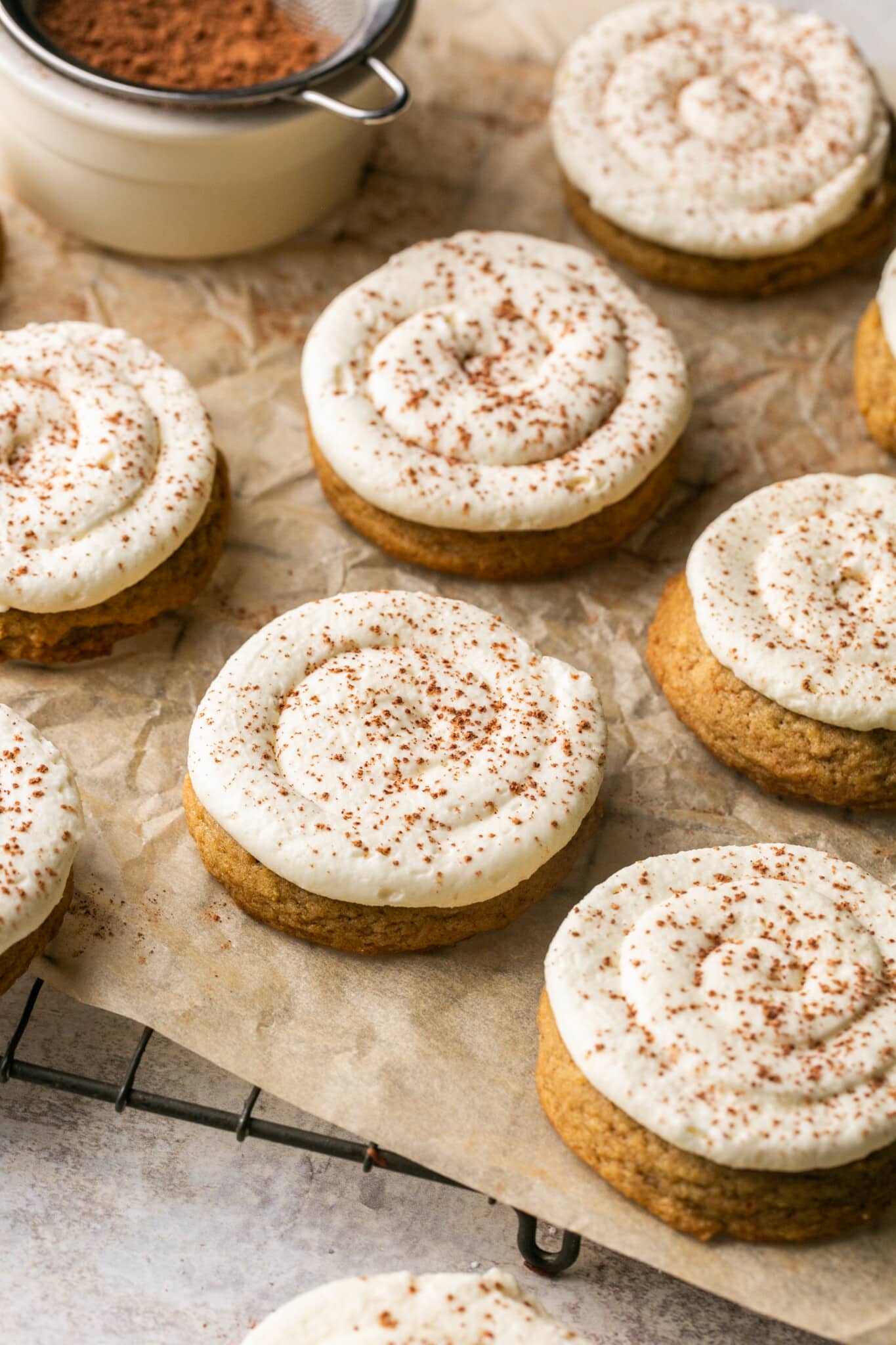 cookies on parchment paper with frosting on top.