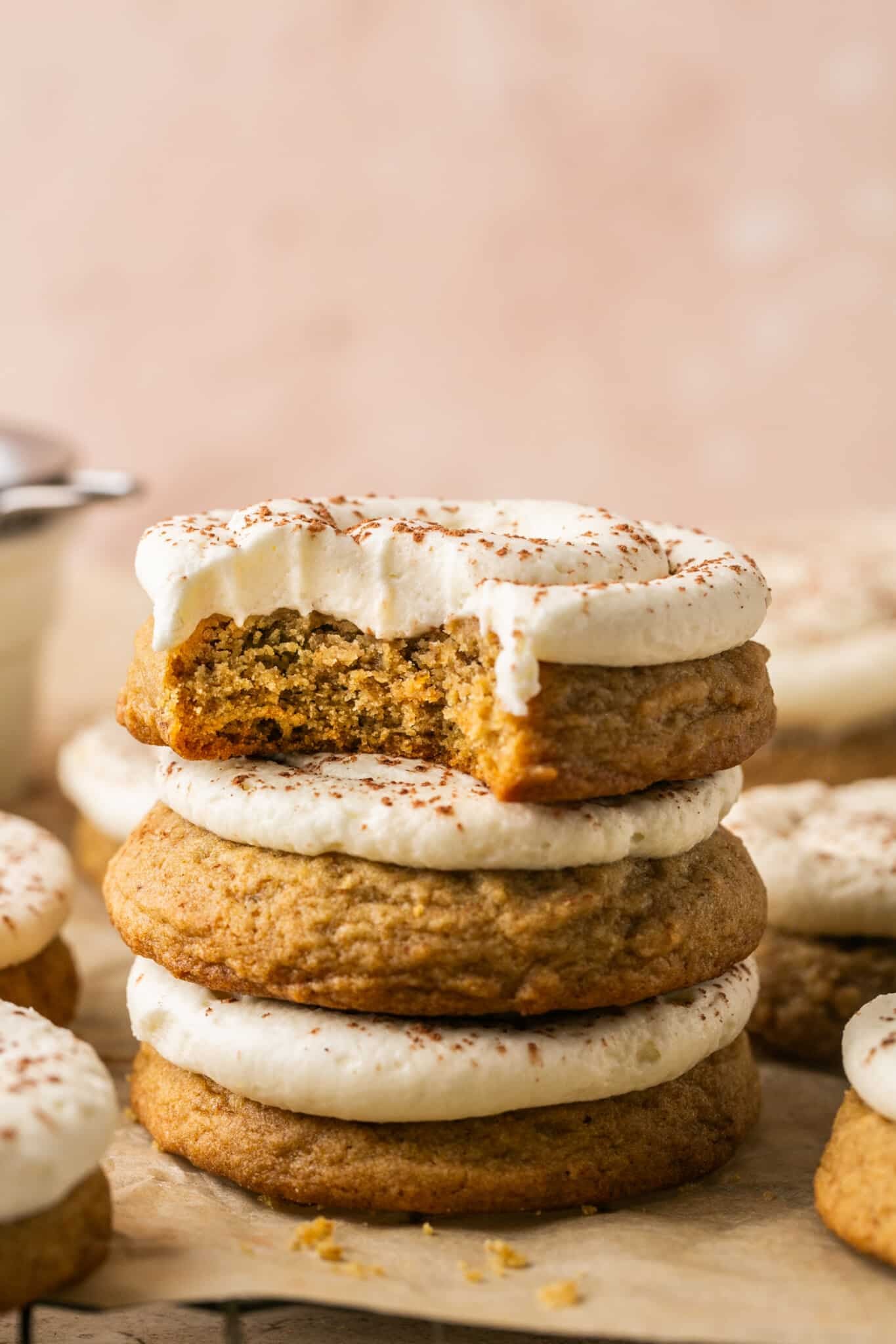 a stack of cookies with frosting on top with a bite taken out of the top cookie. 