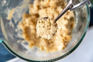 cookie scoop removing cookie dough from clear bowl