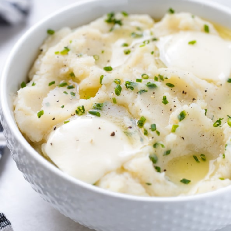 white bowl of mashed potatoes with chives