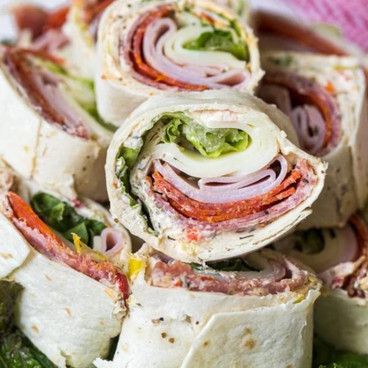 plate of pinwheels made of cheese, meat, lettuce wrapped in a tortilla