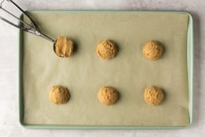 six balls of unbaked cookie dough on a shset