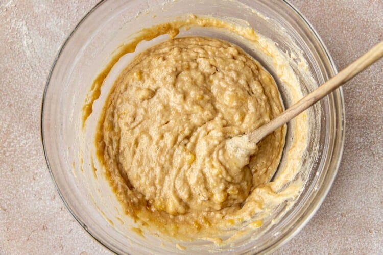 clear bowl with banana bread batter and a spoon