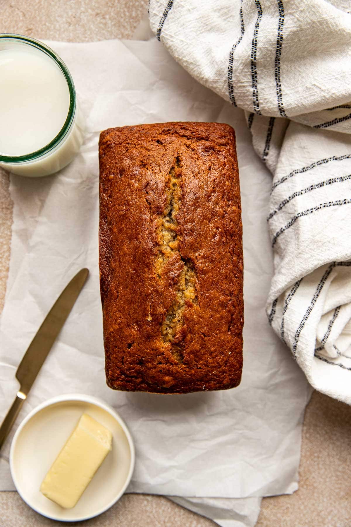 a loaf of banana bread on white parchment paper. 