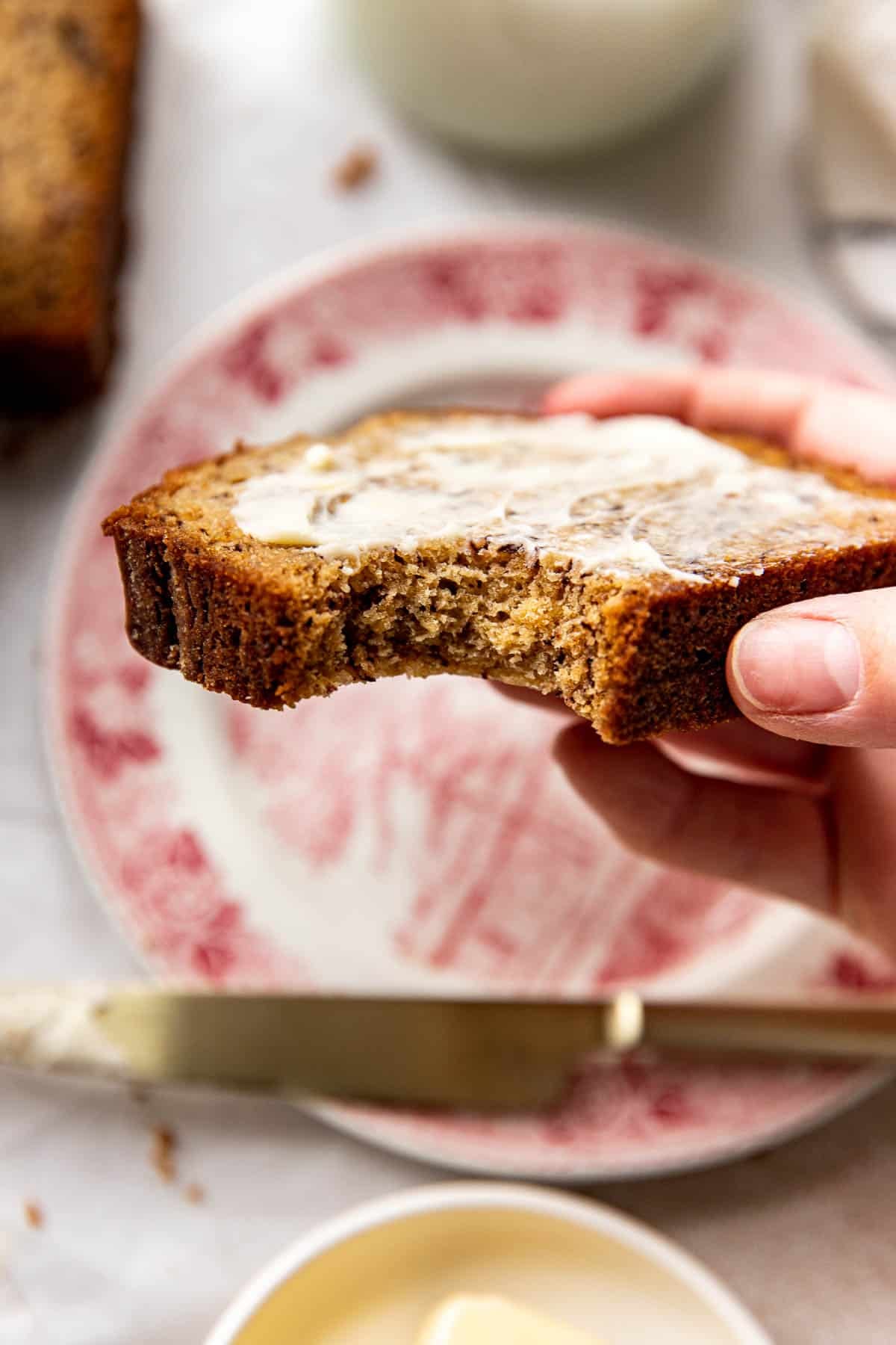 a bite taken out of a slice of banana bread. 