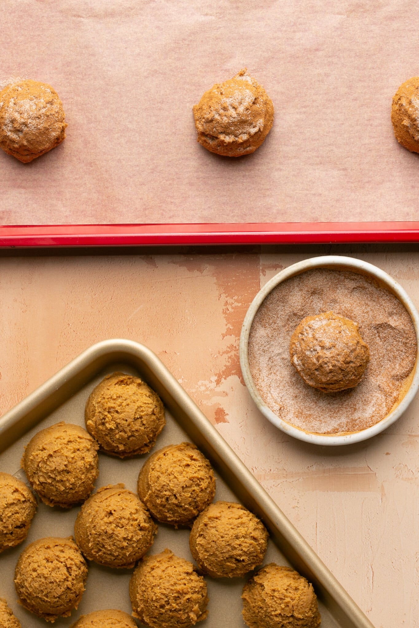 cookie dough being rolled in cinnamon and sugar. 