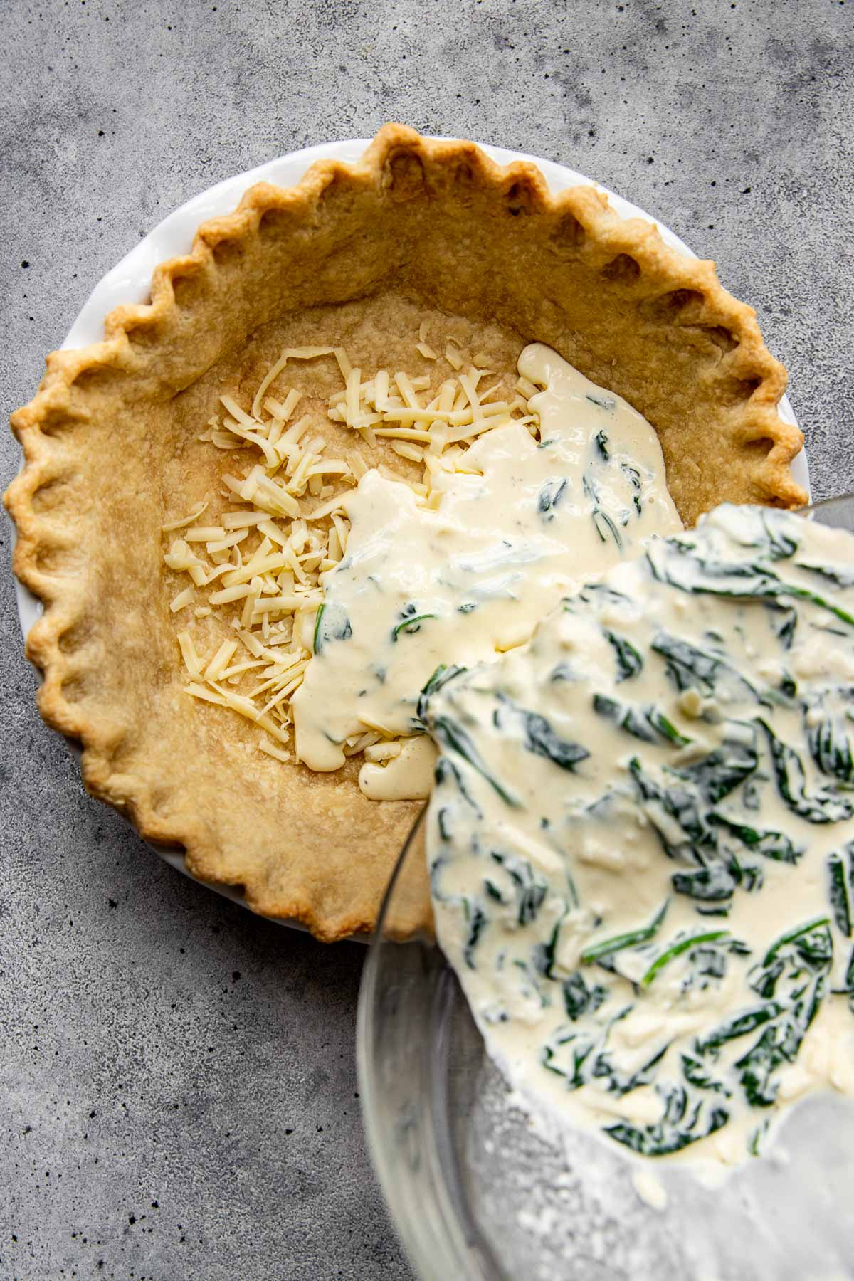 quiche filling being poured onto crust. 