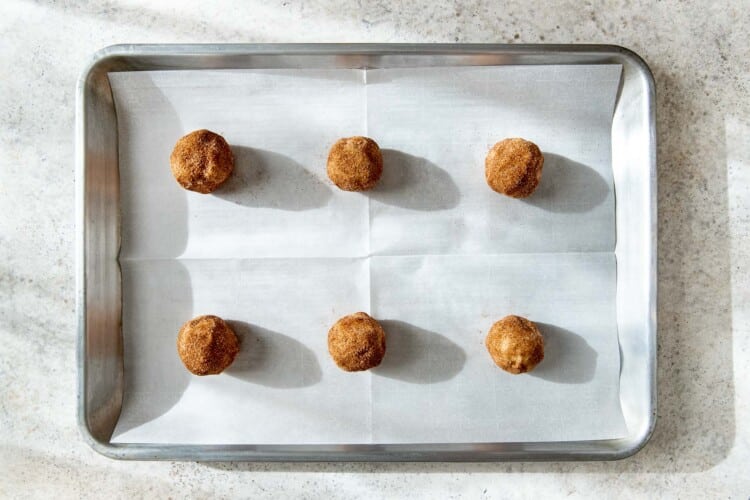 snickerdoodle cookie dough balls on a baking sheet