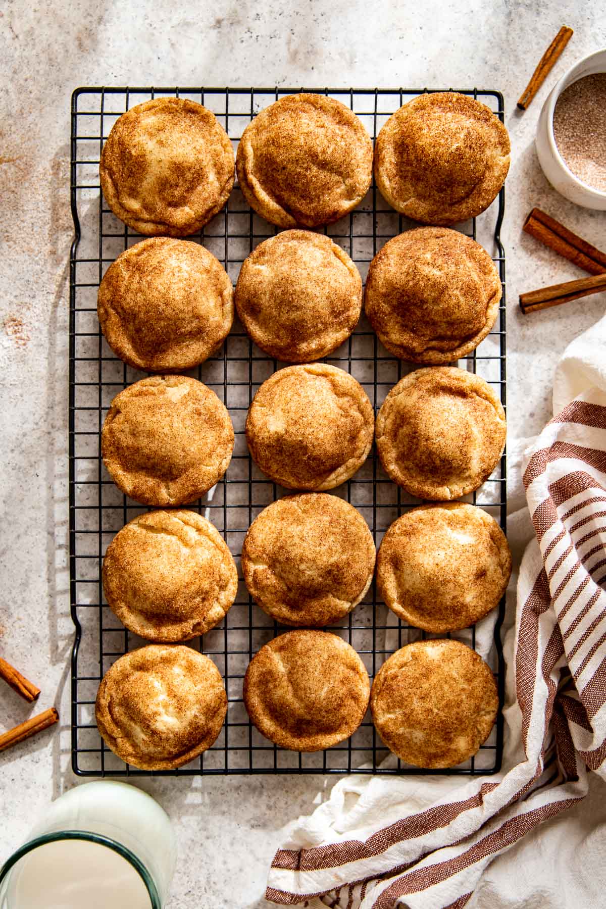 snickerdoodles cookies on a black wire cooling rack. 