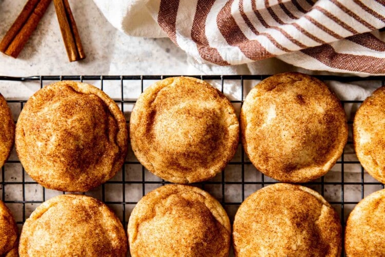 puffy snickerdoodle cookies resting on a cooling rack