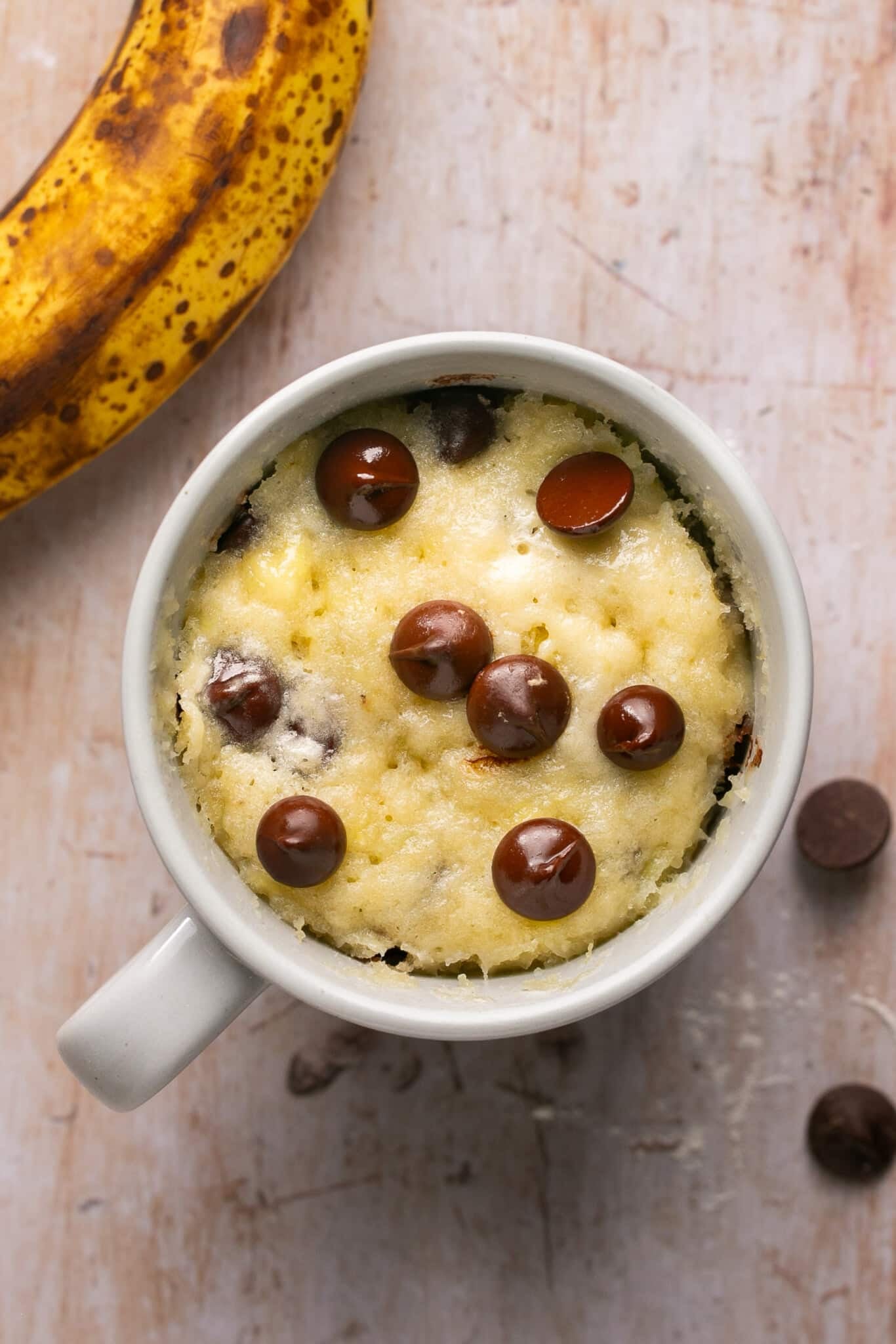 mug cake baked in a white ceramic mug toped with chocolate chips.