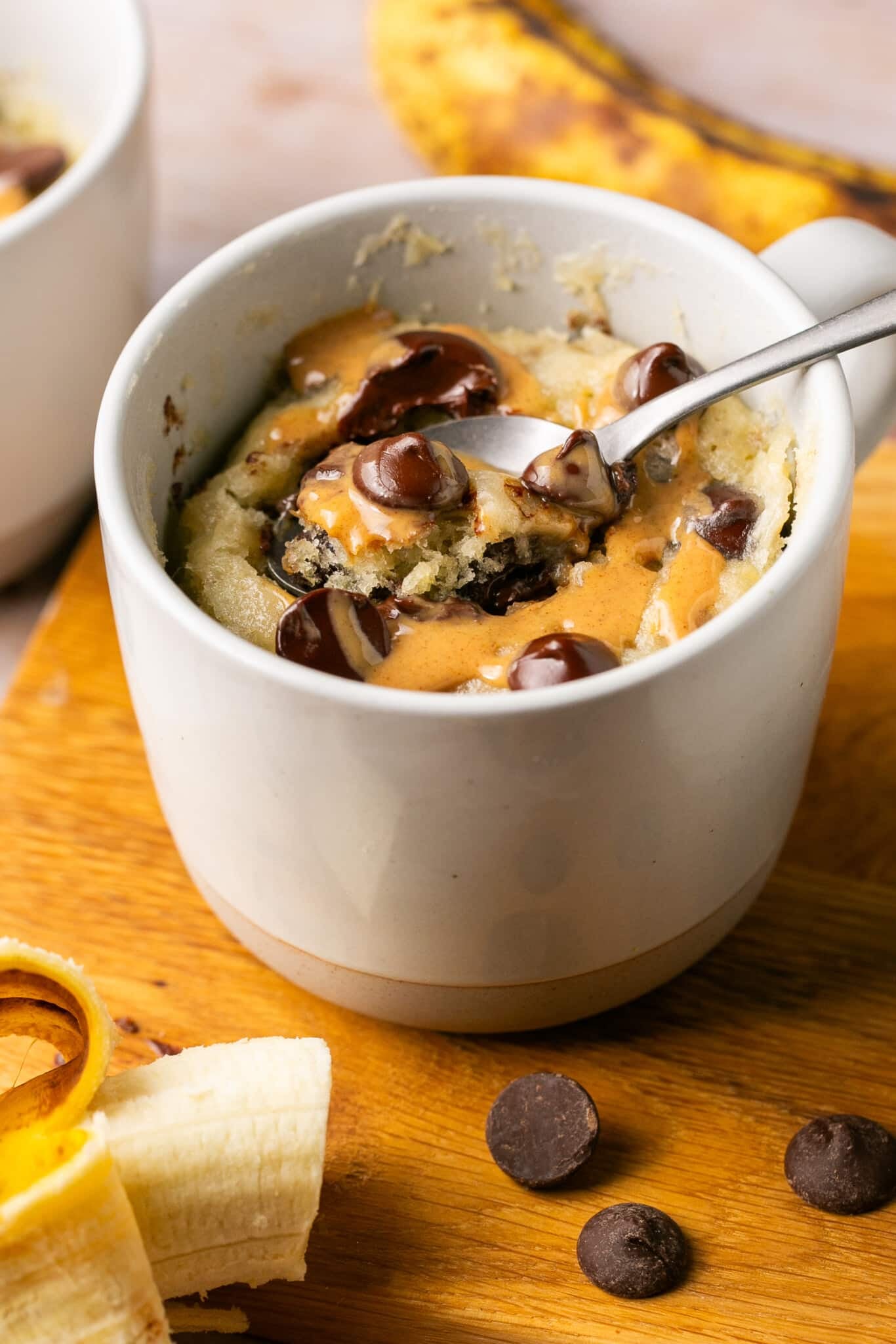 a spoon taking a bite out of a mug cake.