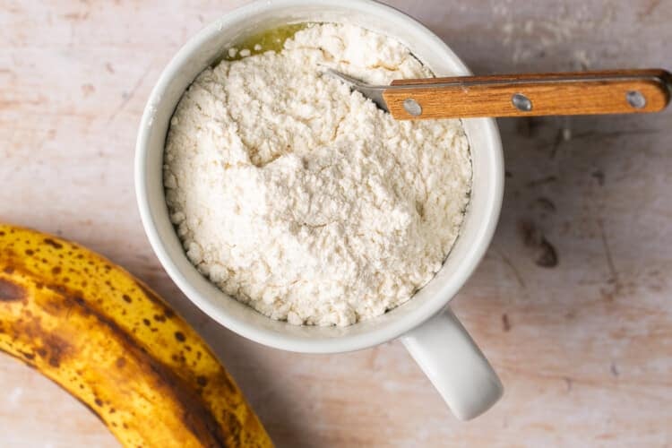 flour inside of a mug to make a mug cake.