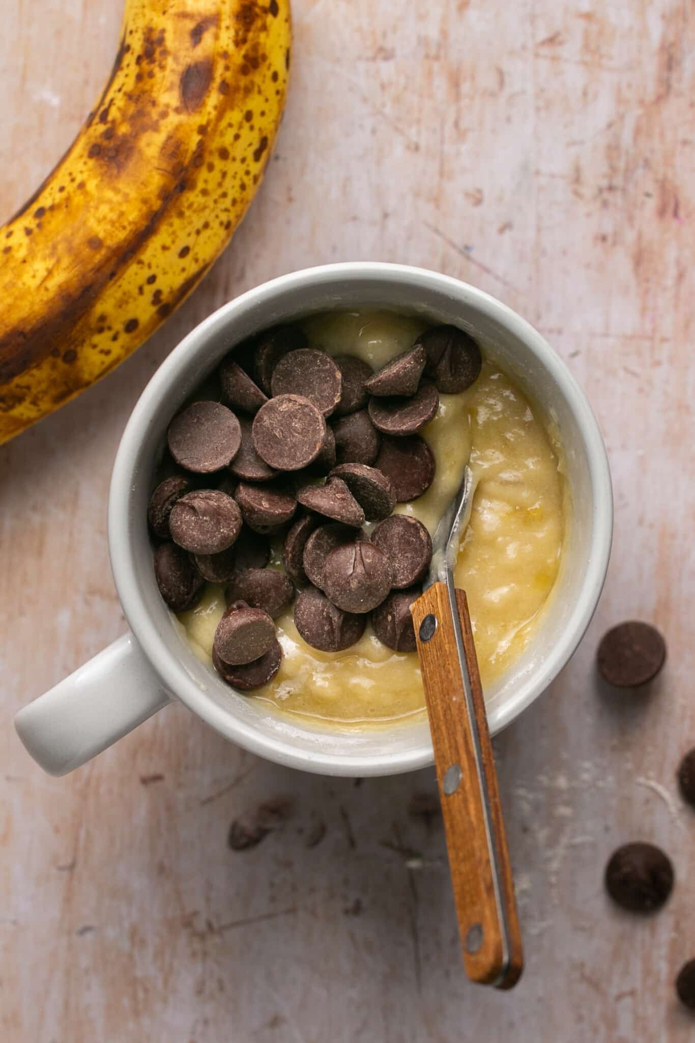 mug cake batter in a mug with chocolate chips on top.