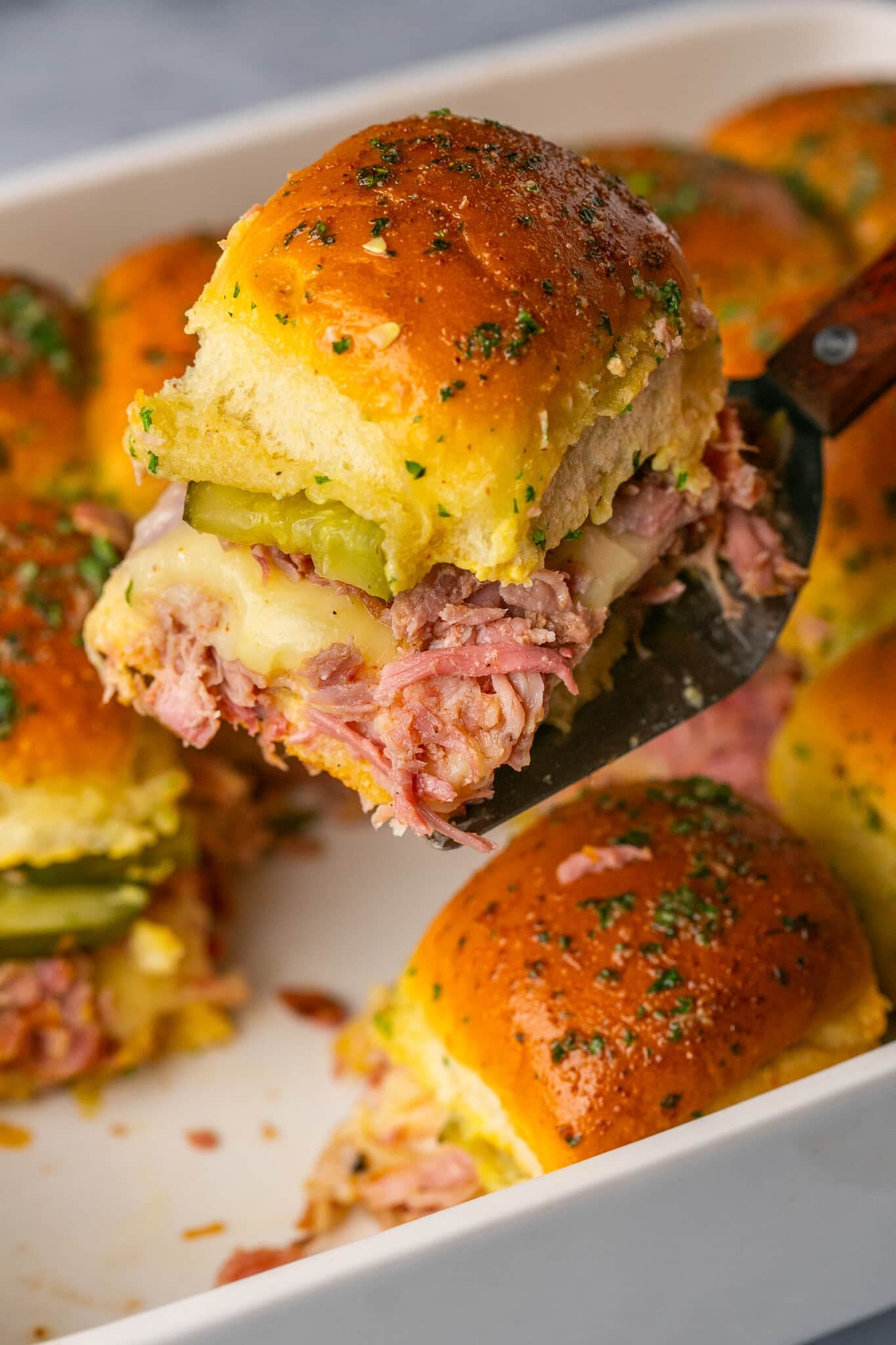 cuban sliders on a serving spatula. 