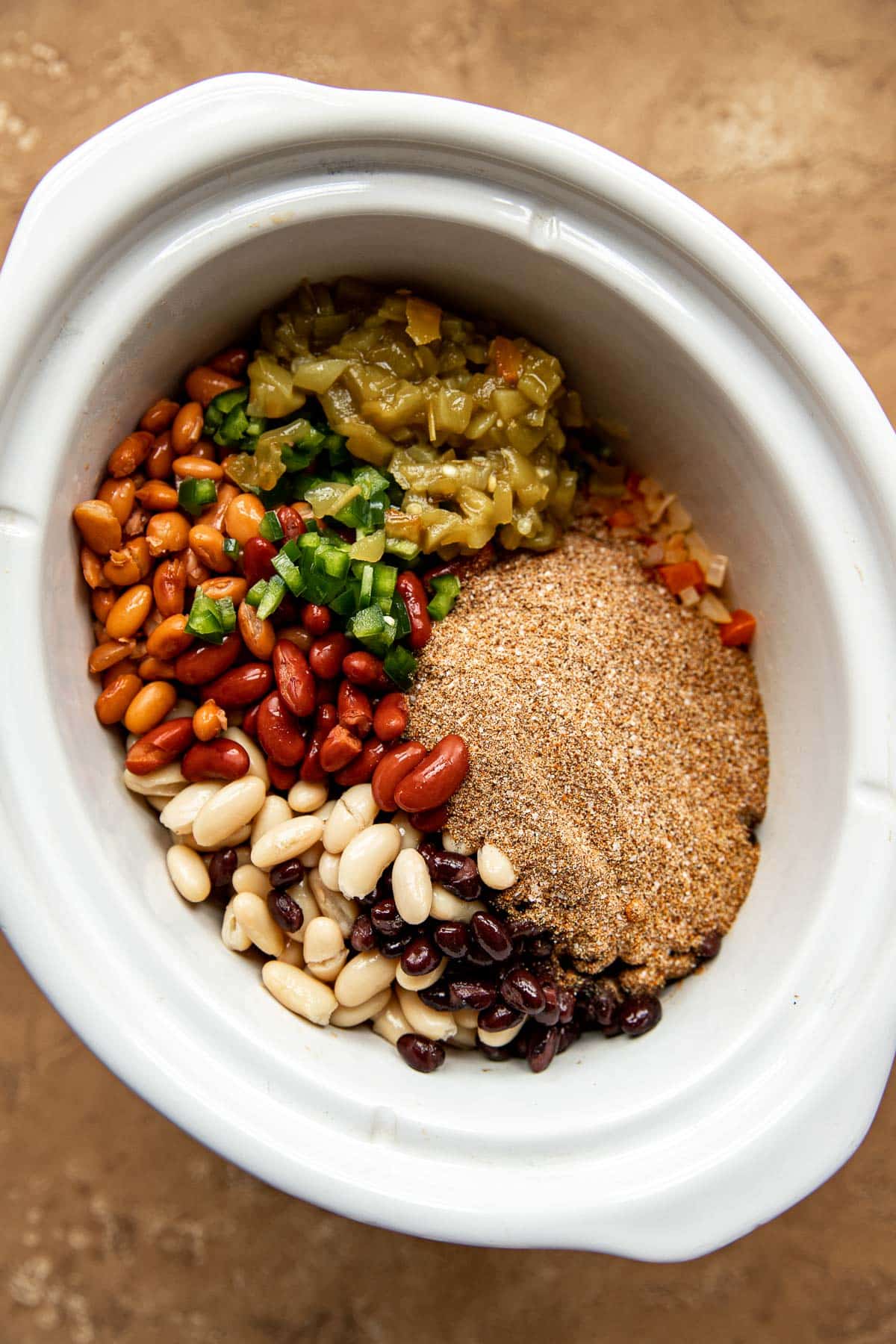 chili ingredients in a white crockpot.