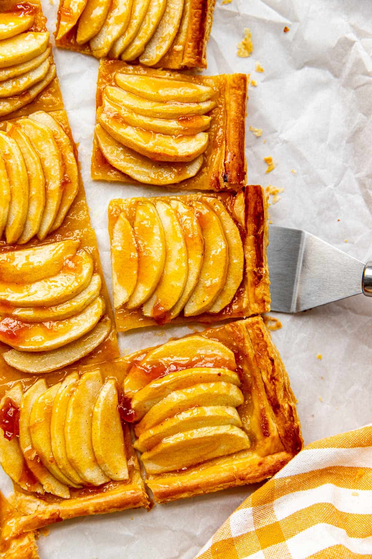 an up close image of an apple tart made with puff pastry and apricot preserves brushed on top. 