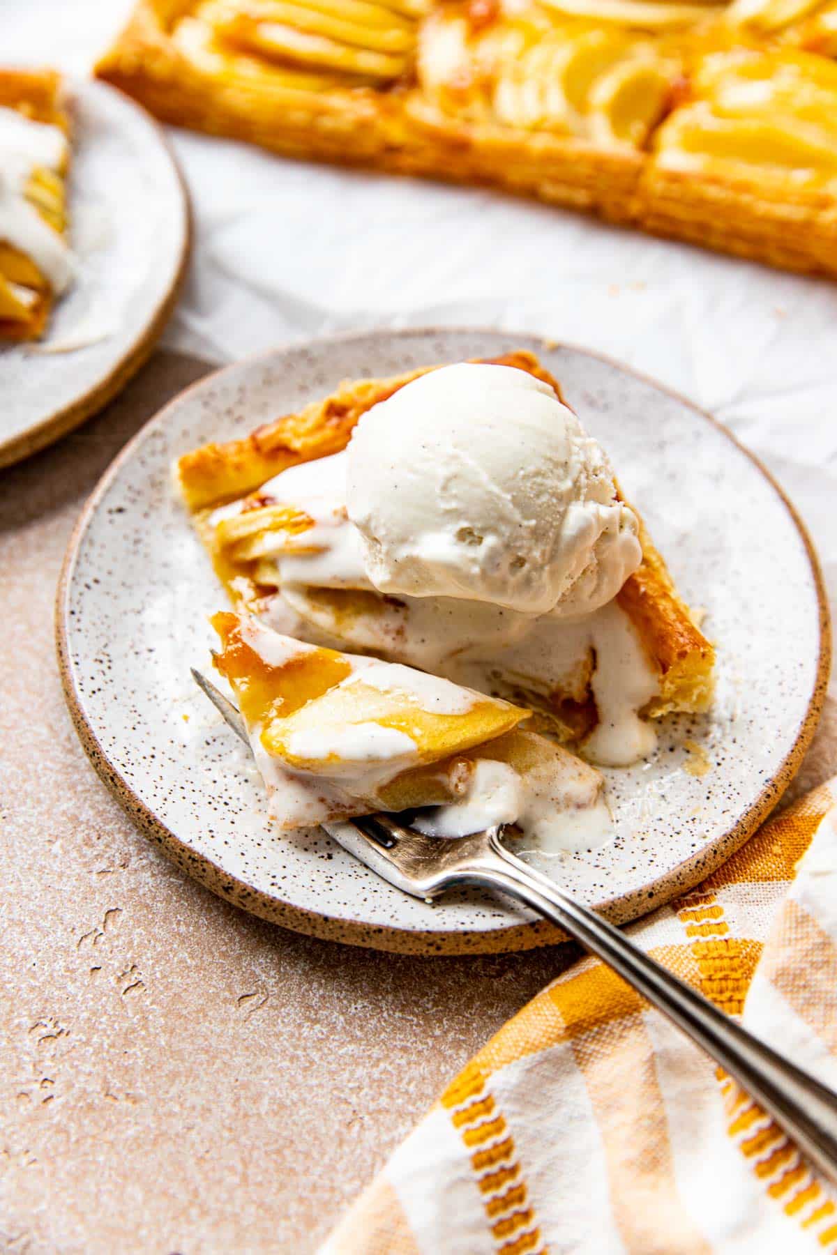 apple tart made on puff pastry with a scoop of ice cream on top. 