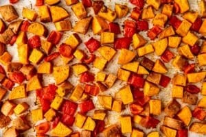 roasted sweet potatoes and bell peppers on a sheet pan.