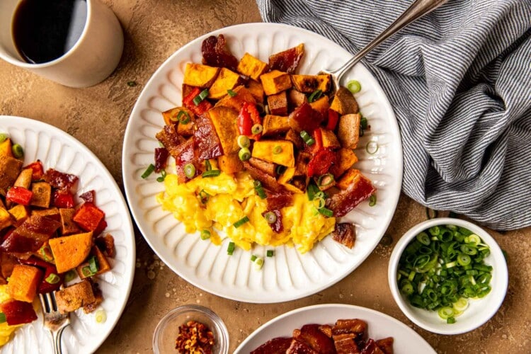 eggs, sweet potato and bacon on a white plate.