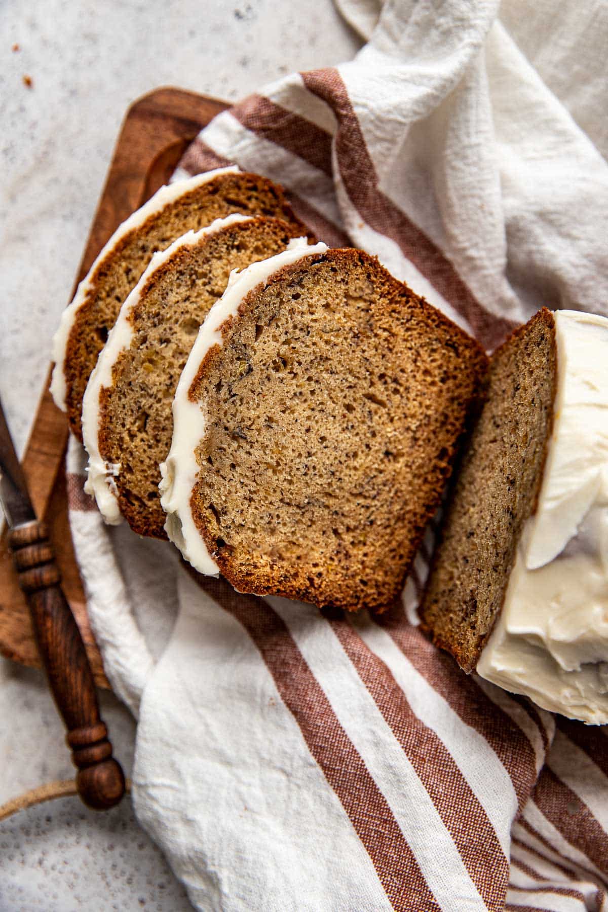 sliced banana bread on a wooden cutting board. 