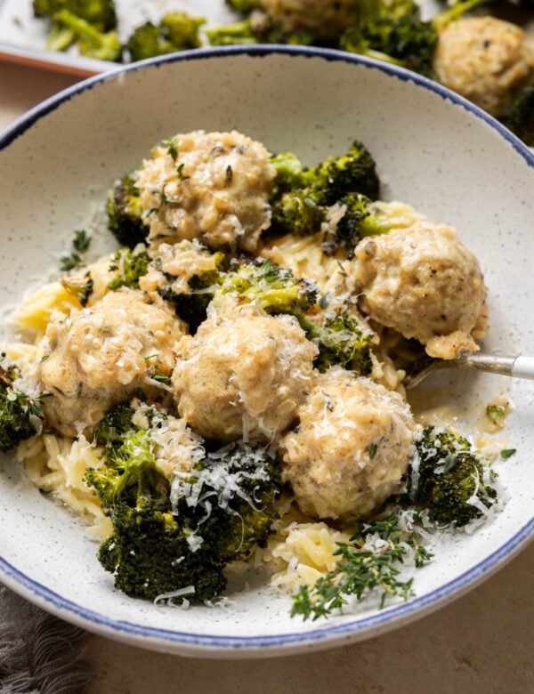 Chicken meatballs with broccoli and orzo in a bowl.