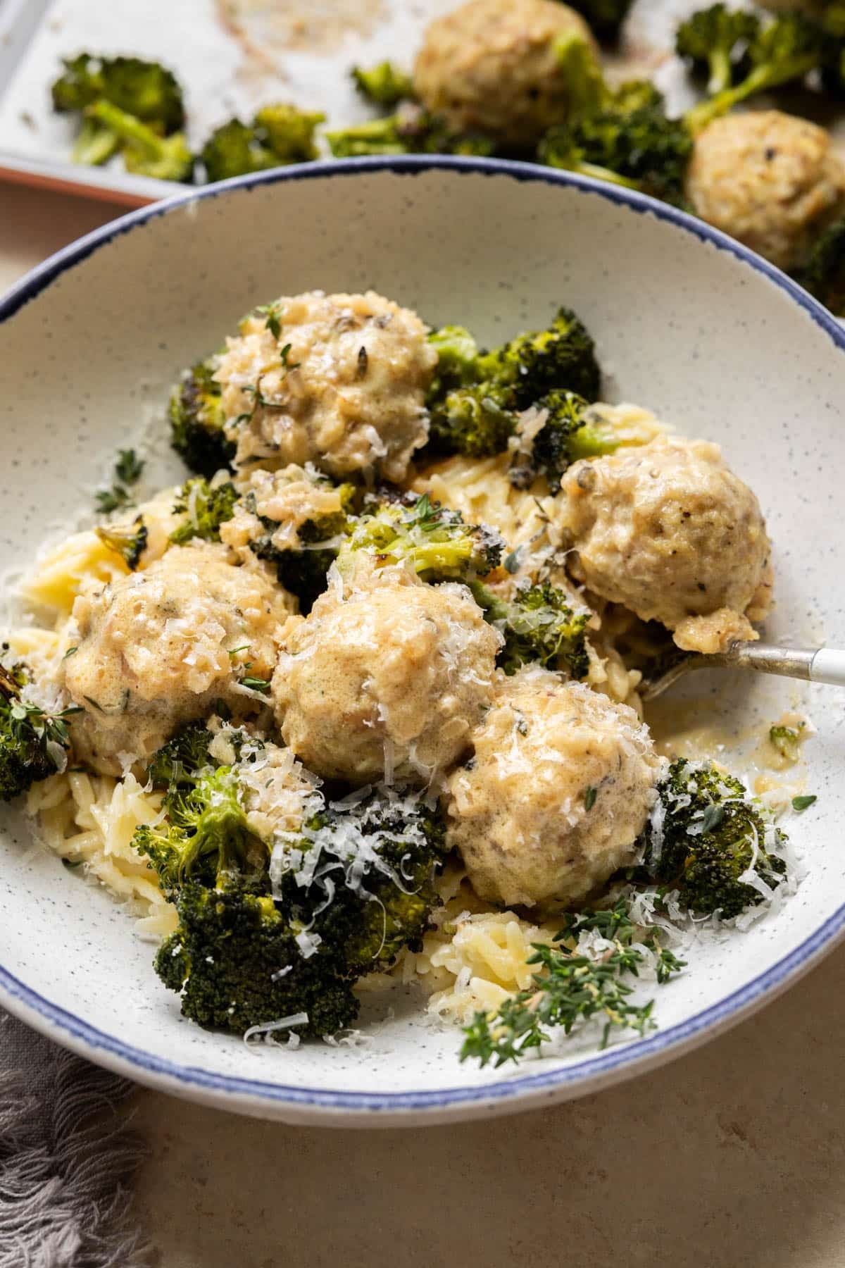 Chicken meatballs with broccoli and orzo in a bowl.
