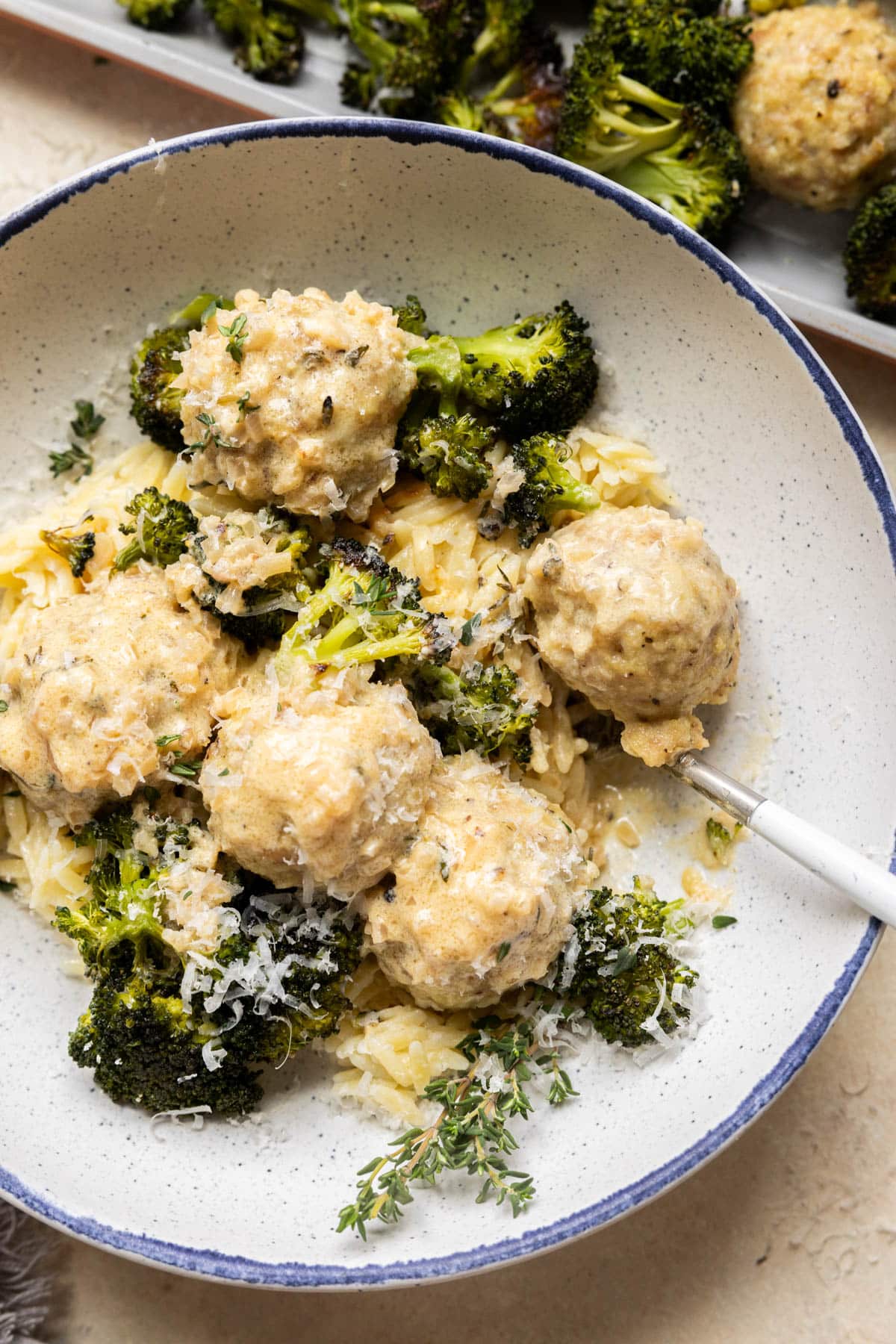chicken meatballs with broccoli and orzo in a bowl. 