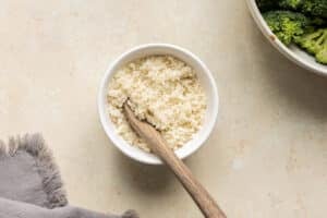Panko breadcrumbs mixed with half and half in a small white bowl.