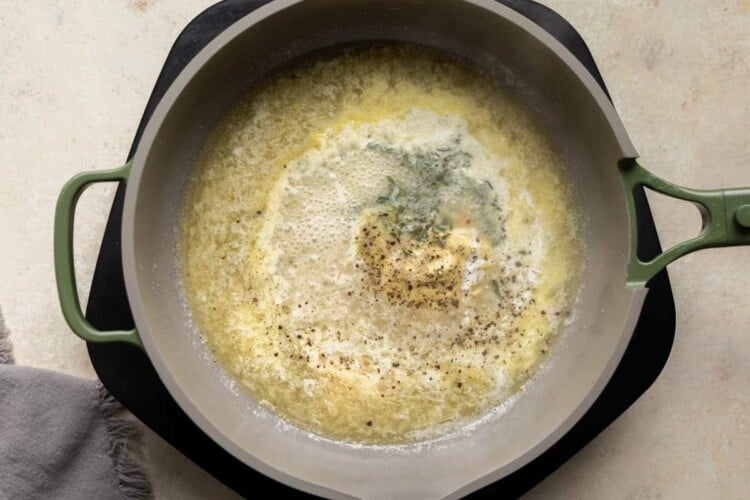 Shallot and butter with fresh thyme and mustard in a sauté pan.