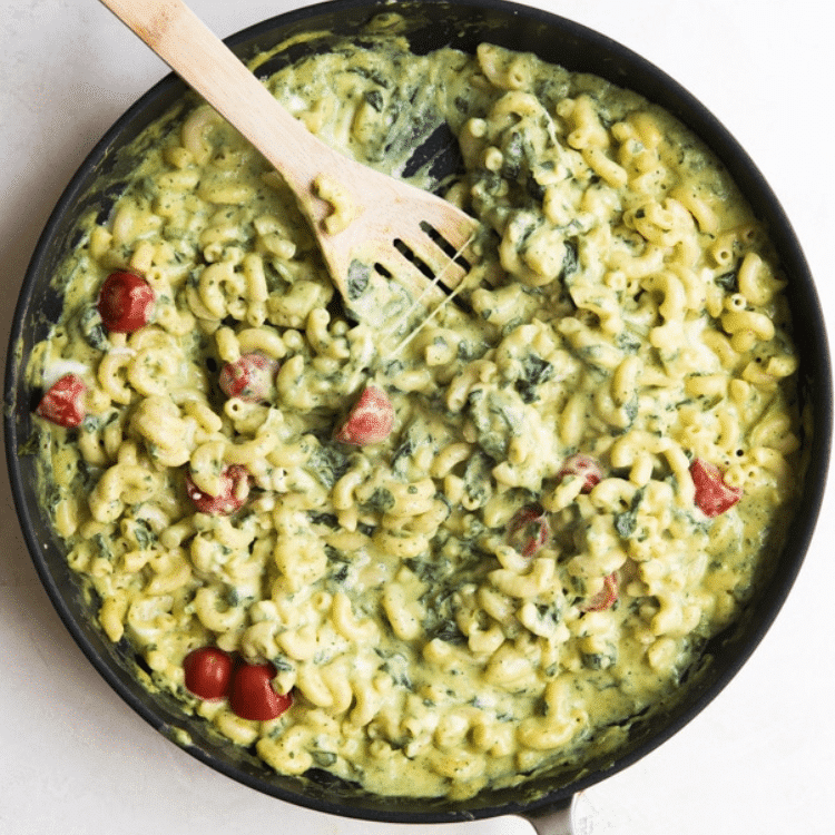 cast iron skillet with green macaroni and small tomatoes