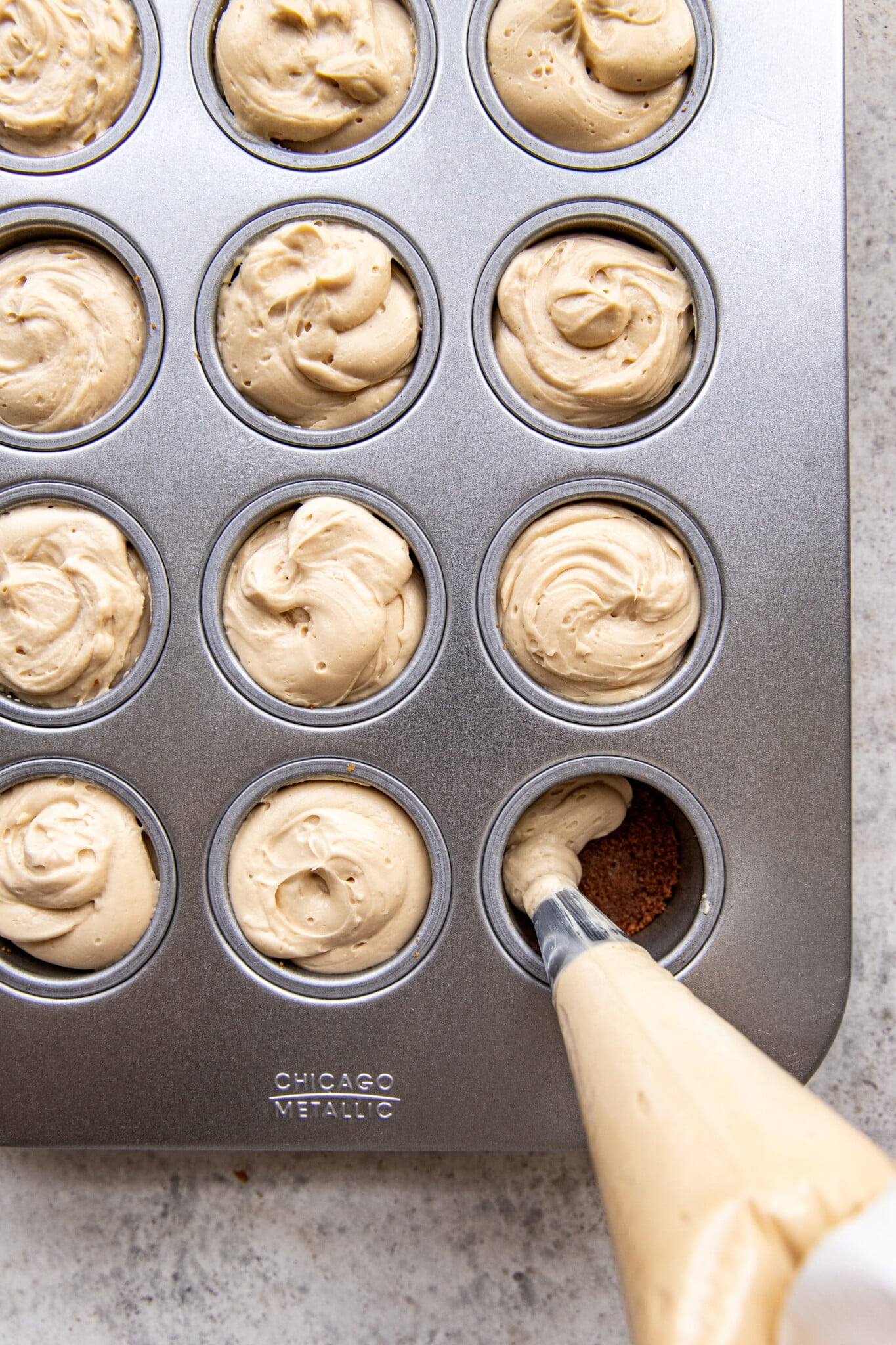 cheesecake being piped into a cheesecake pan.