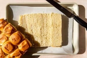 sliced rolls on a parchment paper lined baking sheet.