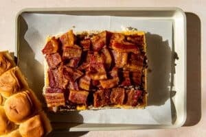 rolls with bacon on a parchment paper lined baking sheet.