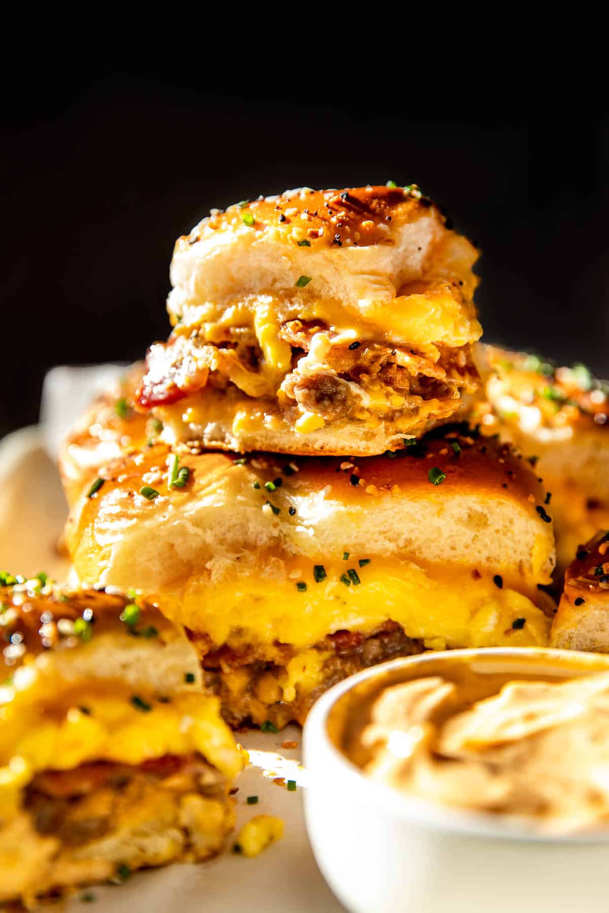 breakfast sliders stacked on top of each other garnished with fresh chives. 