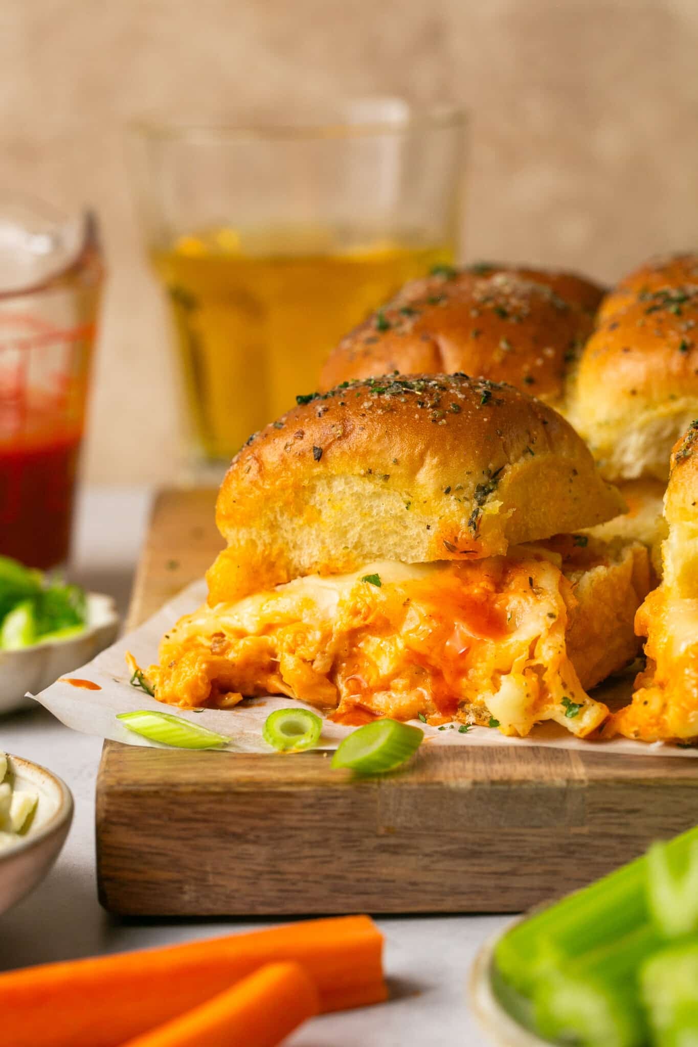 buffalo chicken sliders on a wooden cutting board. 
