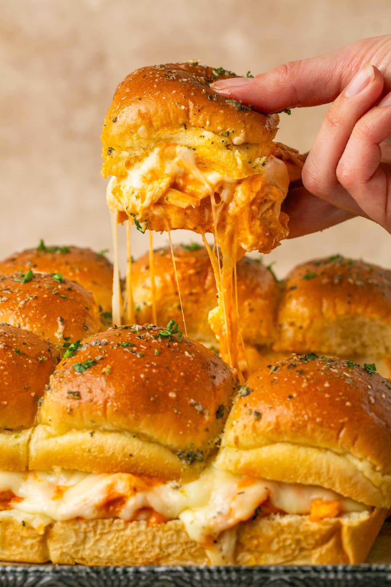 a hand holding a buffalo chicken slider.