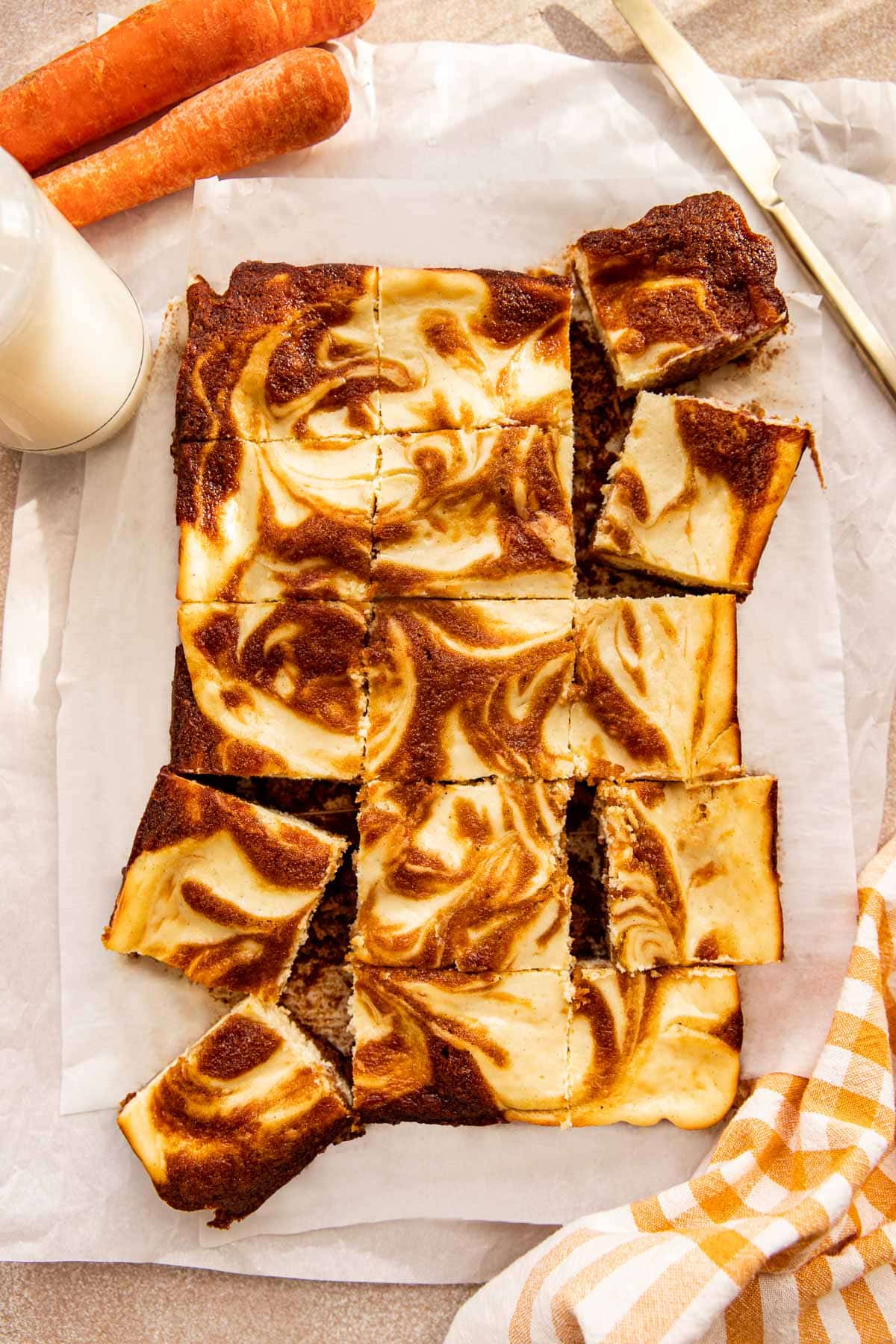 carrot cake bars cut into squares on parchment paper. 