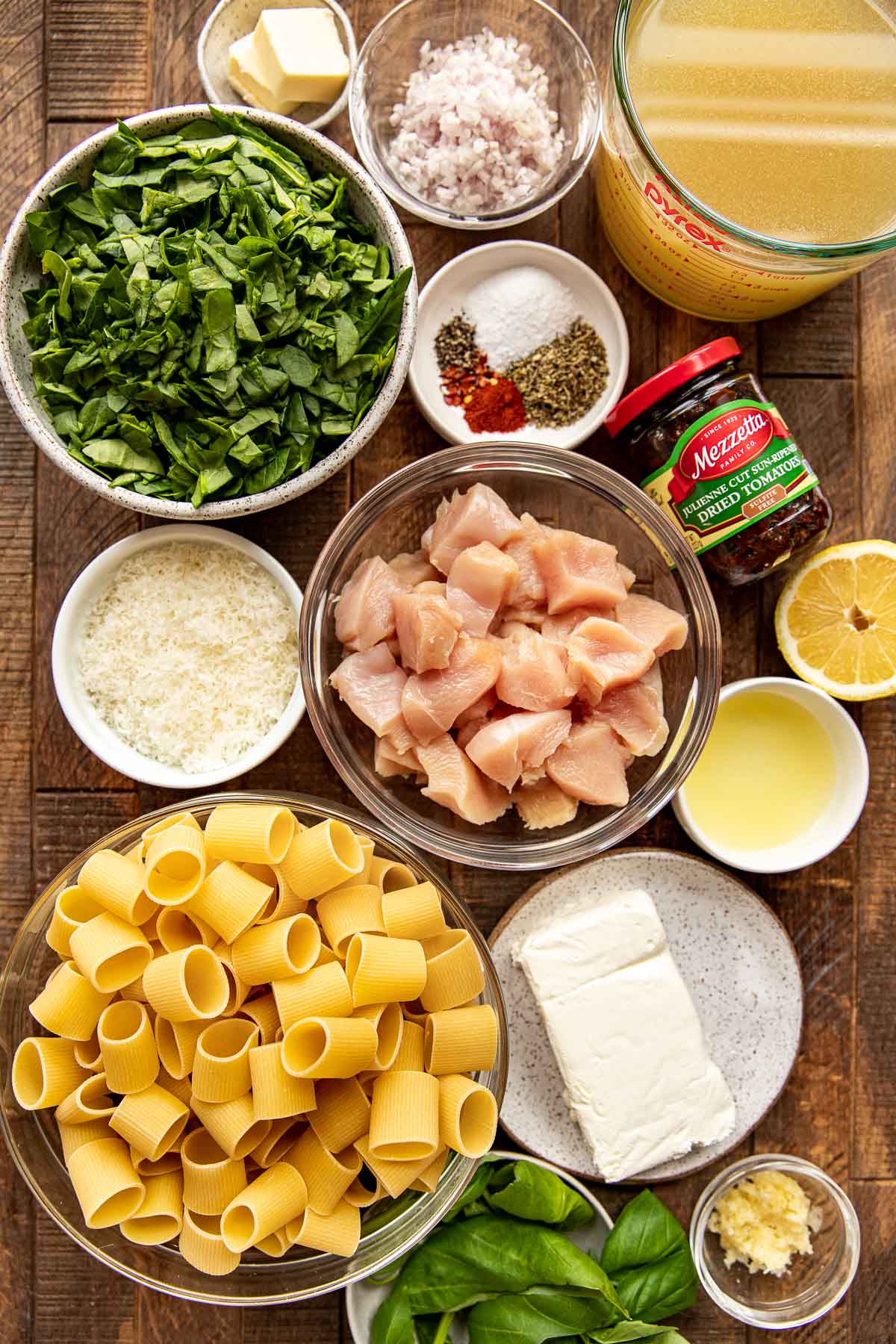 ingredients to make marry me pasta in small glass dishes on a wooden board.