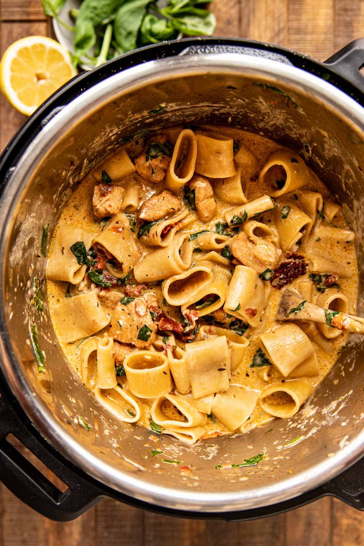 chicken pasta in an instant pot with spinach and a creamy sauce.