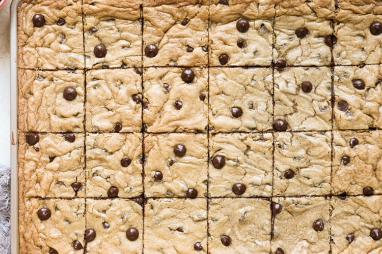 an up close image of chocolate chip cookies cut into squares on a sheet pan.