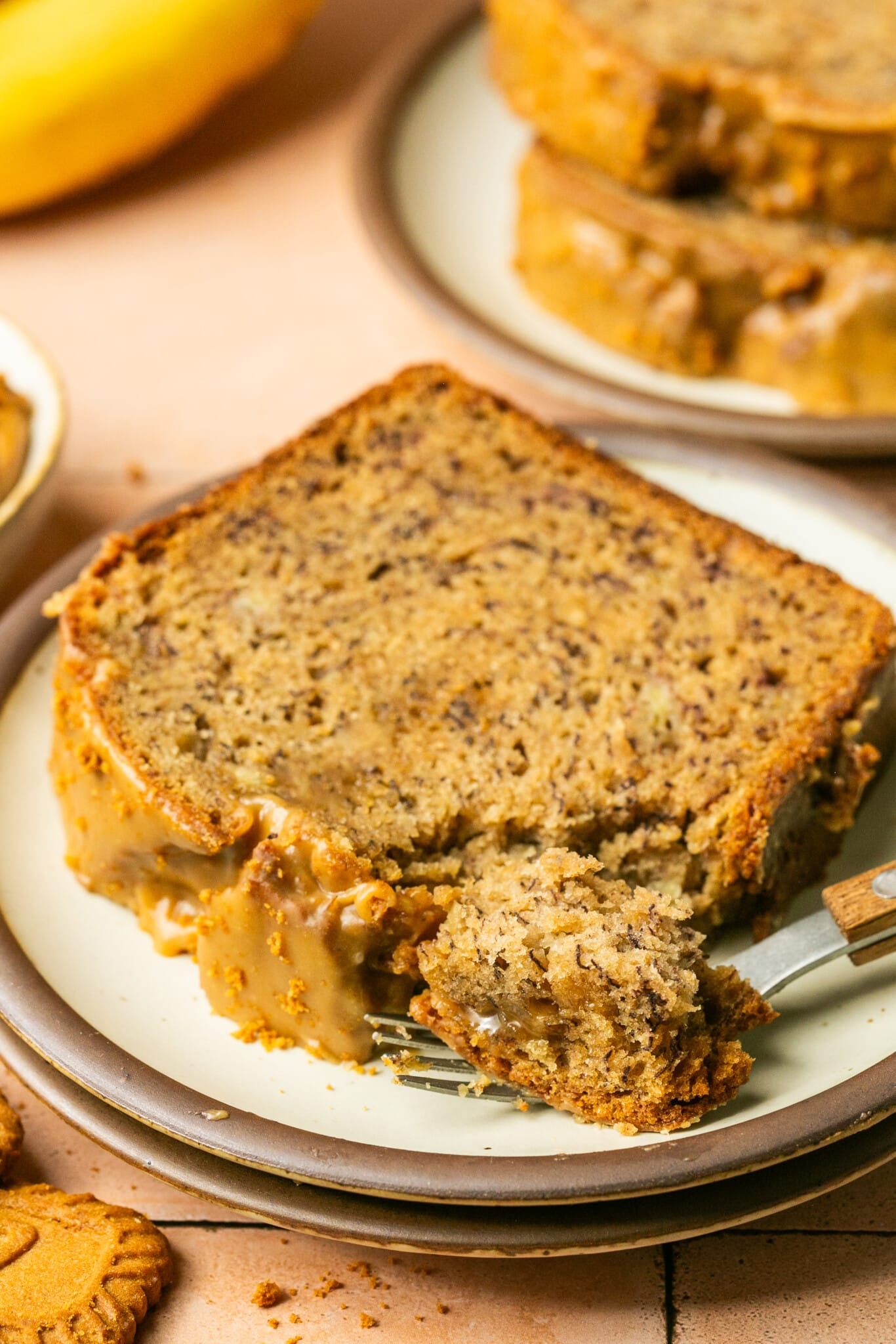 a fork taking a bite out of banana bread. 
