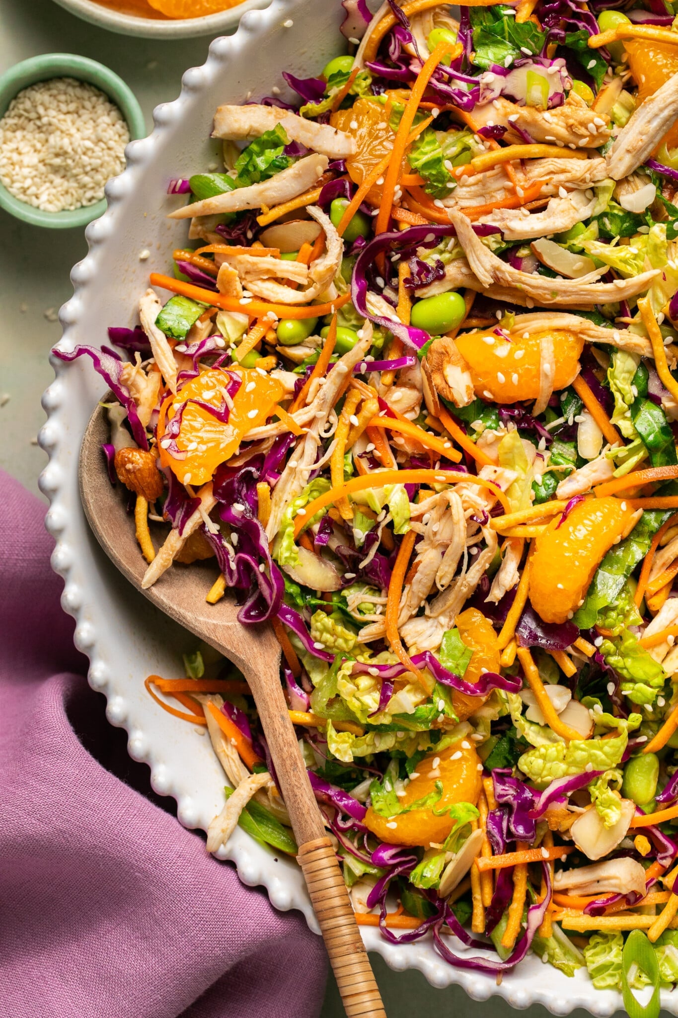 an up close images of chopped chicken salad in a bowl with a wooden serving spoon.