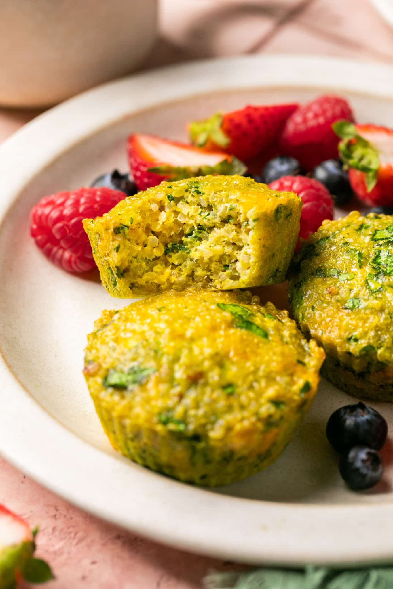 a quinoa egg bite on a plate with fresh fruit. 
