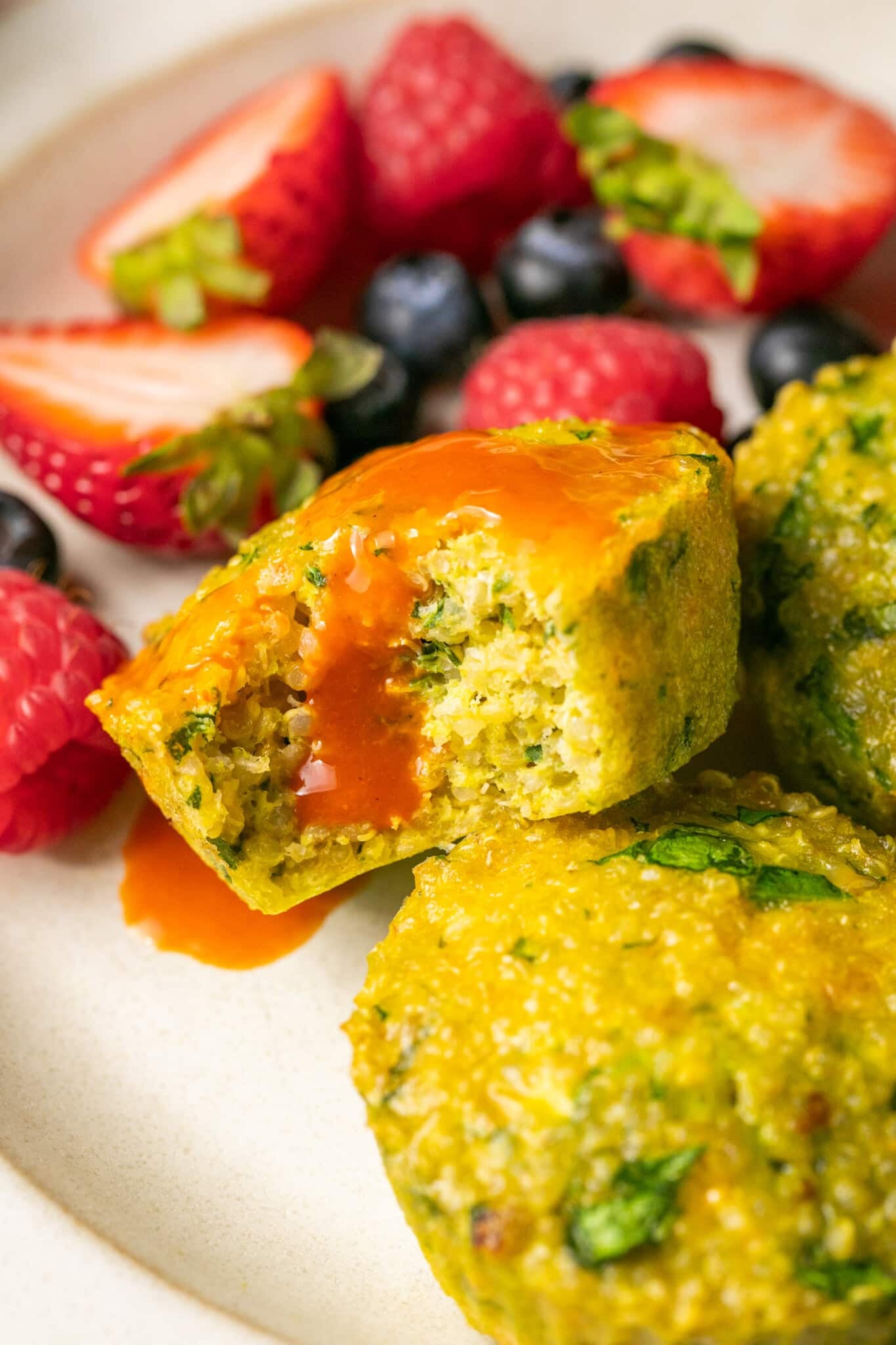 a quinoa egg bite with hot sauce on top of it. 
