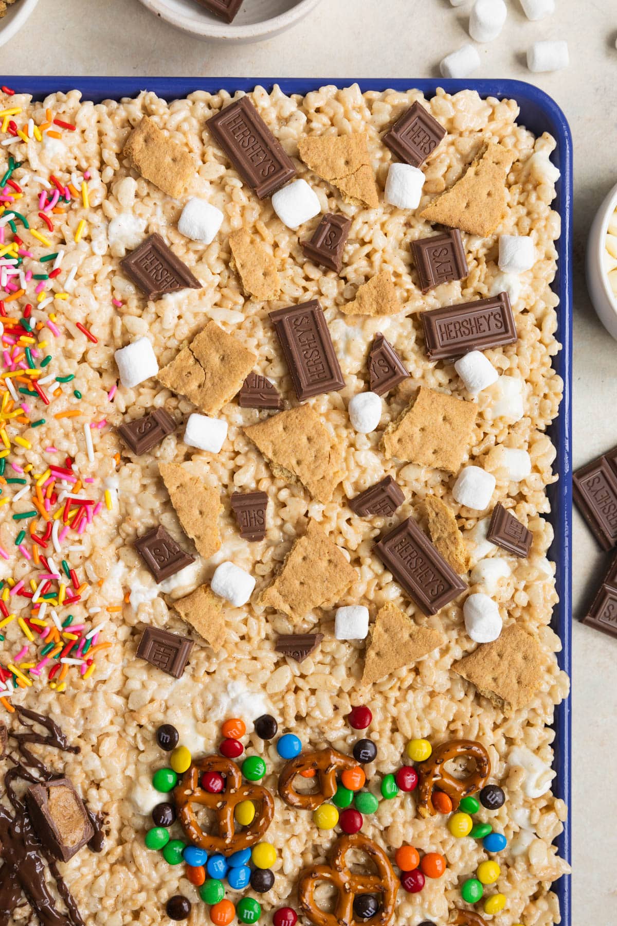 rice krispie treats on a blue sheet pan. 